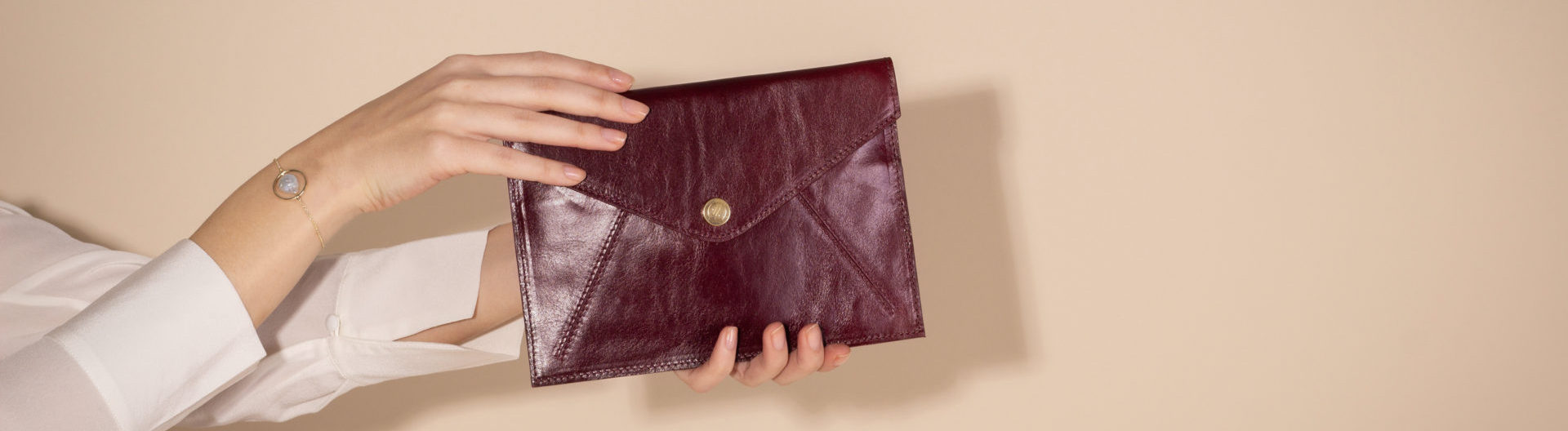 Woman holding Ortona Leather Travel Wallet in Wine by Maxwell Scott
