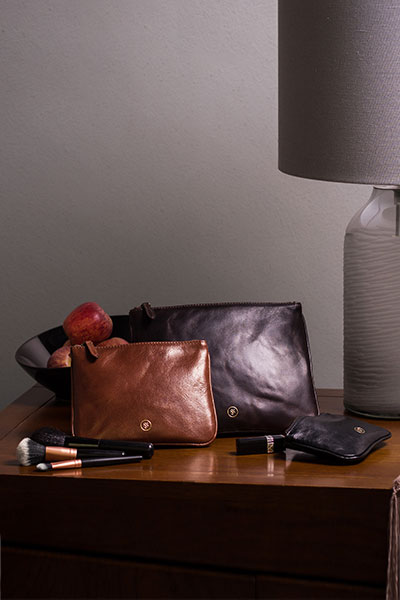 Makeup Bag Trio Sienna by Maxwell Scott on a night stand